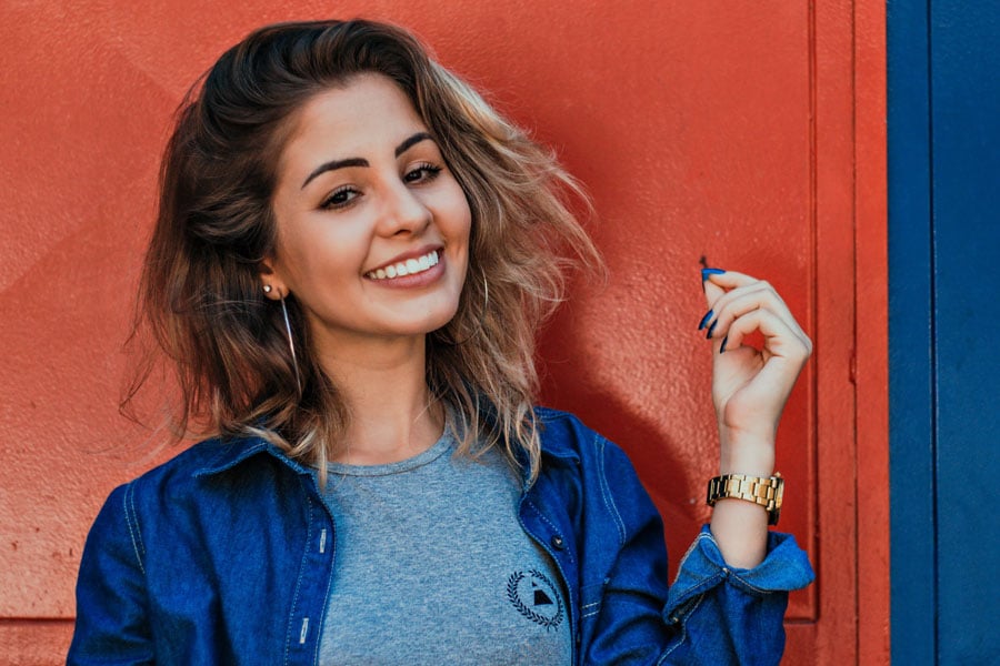 A young woman smiling and showcasing her defined cheekbones