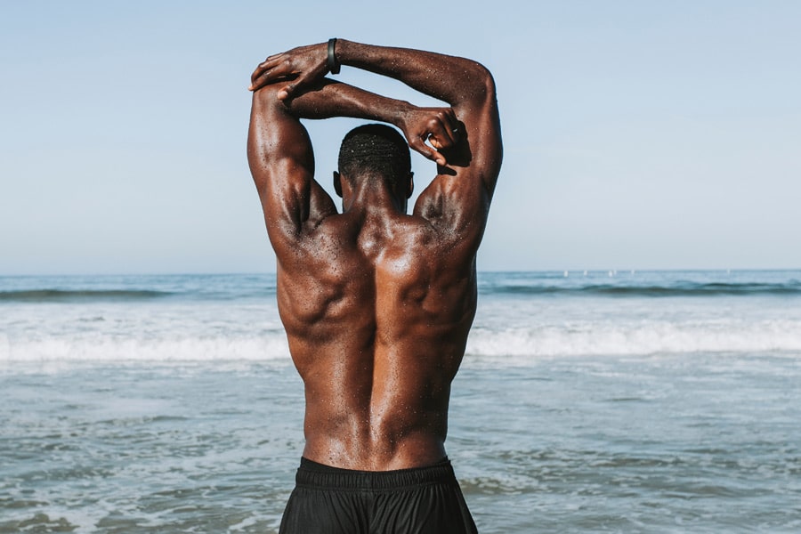Muscular man exercising by the beach