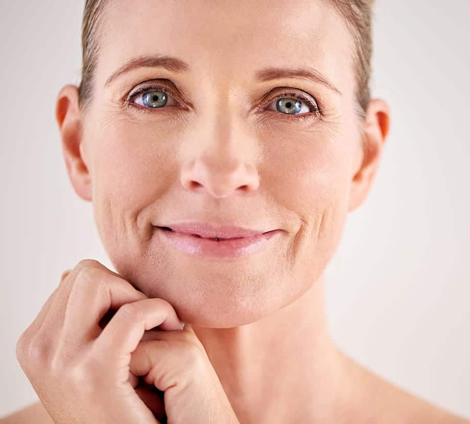 Older woman holding her hands under her chin