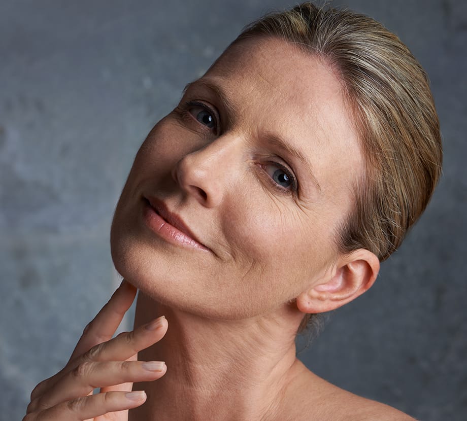 Older woman tilting her head back with her finger