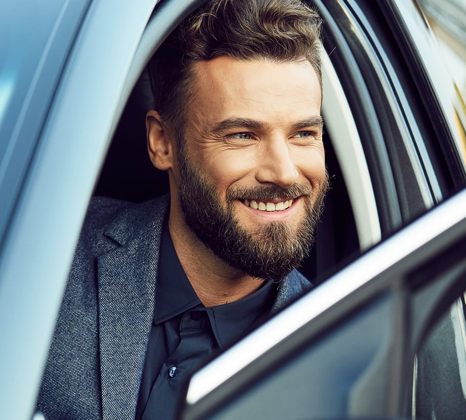 Man sitting in car while looking out window