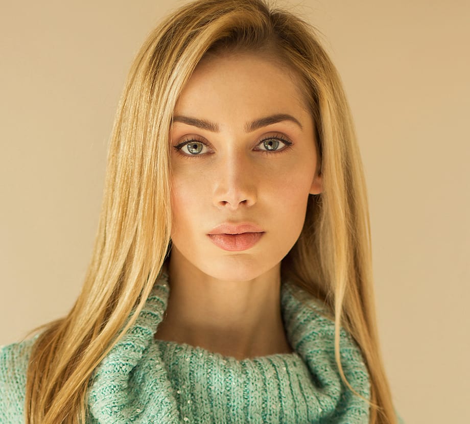 Blonde haired woman looking seriously into camera