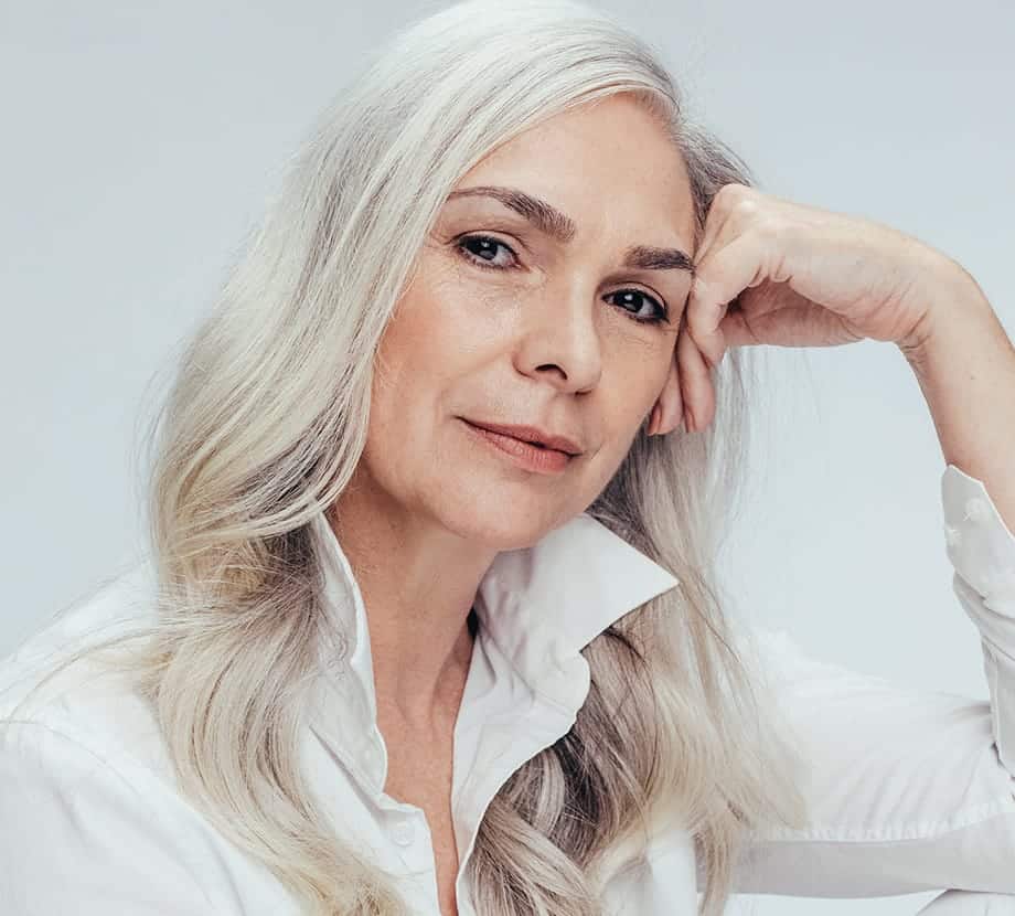 Older woman leaning against her hand while sitting