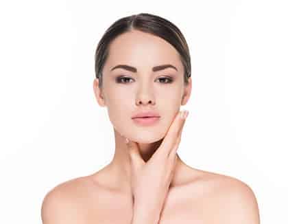 Young woman on white background touching her chin